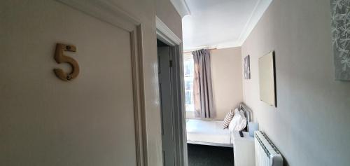 a room with a bedroom with a bed and a number at The Grapes Pub in Southampton