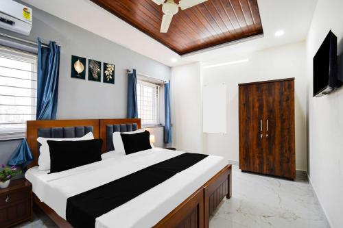 a bedroom with a large bed and a television at Super Hotel O Gachibowli Near ISB in Hyderabad