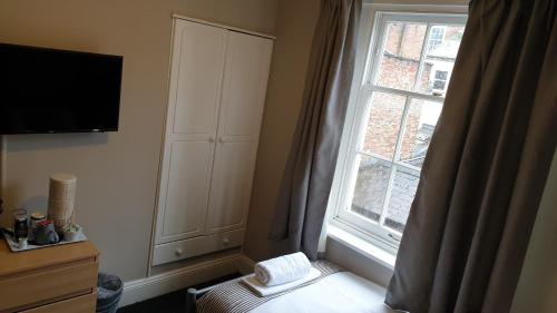 a bedroom with a window and a bed with a towel at The Grapes Pub in Southampton