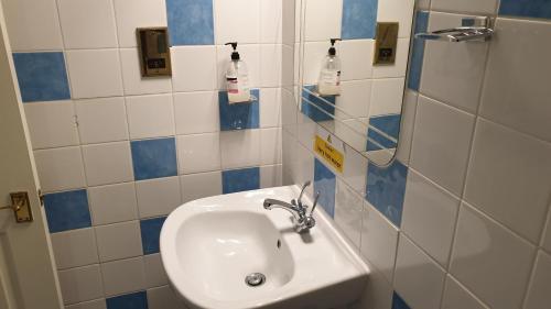 a white sink in a bathroom with blue and white tiles at The Grapes Pub in Southampton
