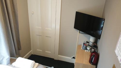 a small room with a television and a bed at The Grapes Pub in Southampton