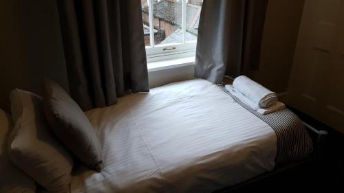 a bed sitting in a room with a window at The Grapes Pub in Southampton