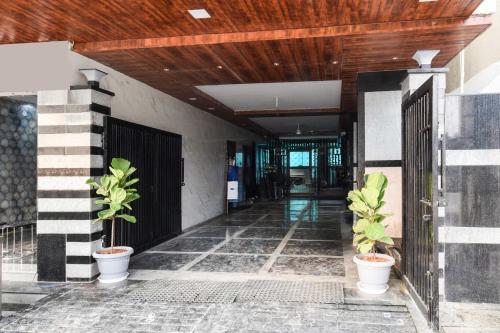 a hallway with two potted plants in a building at Super Hotel O Gachibowli Near ISB in Hyderabad