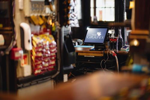 a bar with a laptop computer on a counter at The Grapes Pub in Southampton