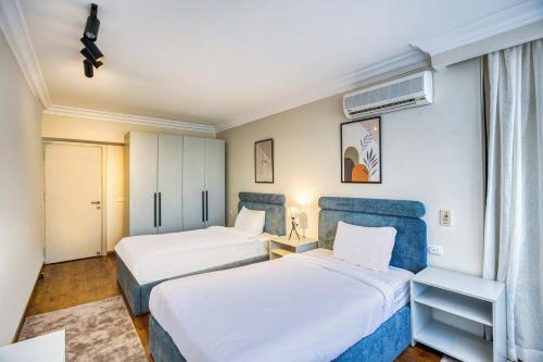 开罗Cairo Homes Maadi Nile View Family的有两张床和一扇窗户的酒店房间