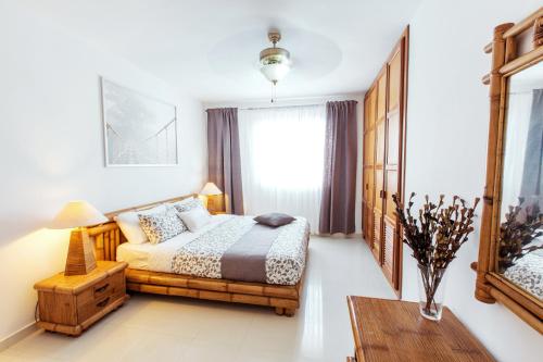 a bedroom with a bed and a table at CARIBBEAN VILLAS and SUITES - LOS CORALES beach - free wifi, free breakfast in Punta Cana