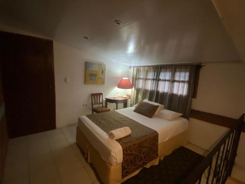 a bedroom with a bed and a chair and a window at Hostal Fuente Castalia, B y B in León
