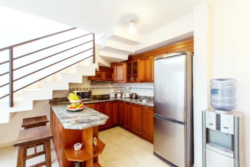 a kitchen with a staircase and a stainless steel refrigerator at CARIBBEAN VILLAS and SUITES - LOS CORALES beach - free wifi, free breakfast in Punta Cana