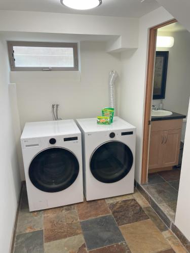 two washing machines in a bathroom with a sink at Dragan's Cove in Oxnard