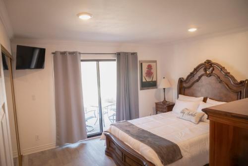 a bedroom with a large bed and a balcony at Surfside Four in Port Hueneme