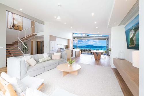 a living room with a white couch and a table at Coastal Haven Retreat - Luxe Airlie Beach Holiday Home in Airlie Beach