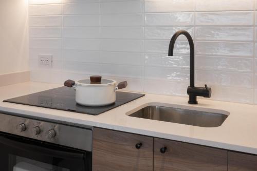a kitchen with a sink and a pot on a stove at Departamento Premium en Puerto Norte con vista al río in Rosario