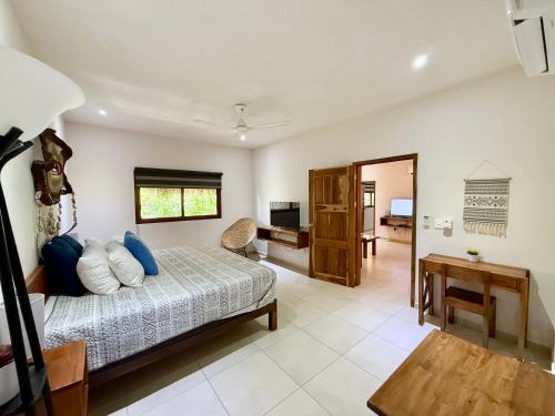 a bedroom with a bed and a desk in a room at La Selva Apartments Tulum in Tulum