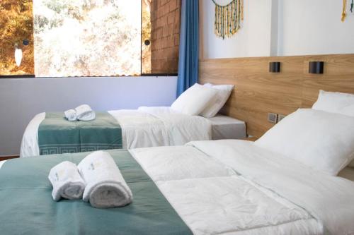 two beds in a room with towels on them at Velvet Sunrise Hotel in Machu Picchu