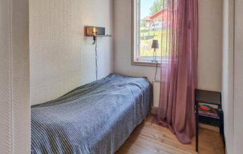 a small bedroom with a bed and a window at Awesome Home In Värnamo With Lake View in Värnamo