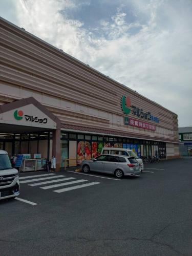 a car parked in a parking lot in front of a store at BEPPU Sento in Beppu