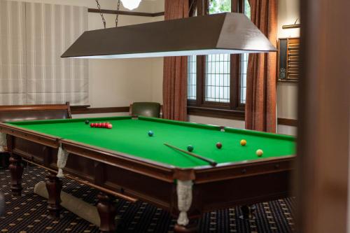 a green pool table in a room with a lamp at The Riverine Club in Wagga Wagga