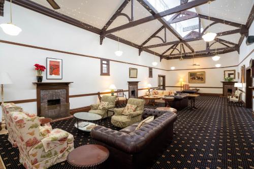 a living room with leather furniture and a fireplace at The Riverine Club in Wagga Wagga