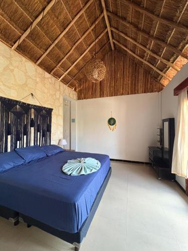 a bedroom with a blue bed in a room at Hotel Itza Coba in Cobá