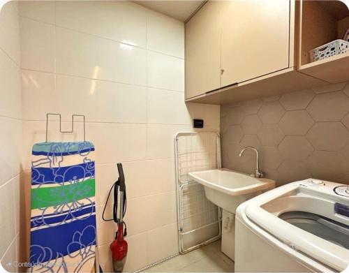 a small kitchen with a sink and a washing machine at 535 Flat Residência in Salvador