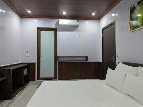 a bedroom with a large white bed and a door at Daisy's Villa TamCoc in Vũ Lâm