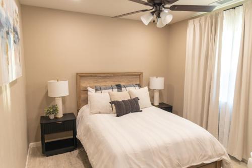 a bedroom with a white bed with two night stands and two lamps at Sequoia Oasis near Downtown Exeter in Exeter