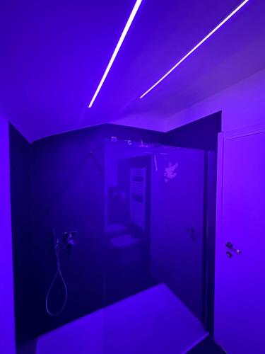a dark room with a purple room with a toilet at Silver Apartment in Agrate Brianza