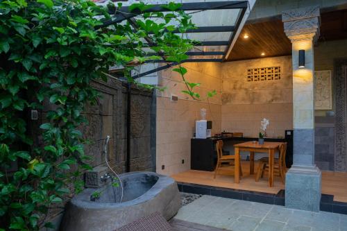 Un jardín con una bañera y una mesa y un comedor. en Ubud Paras Ayu Villa, en Ubud