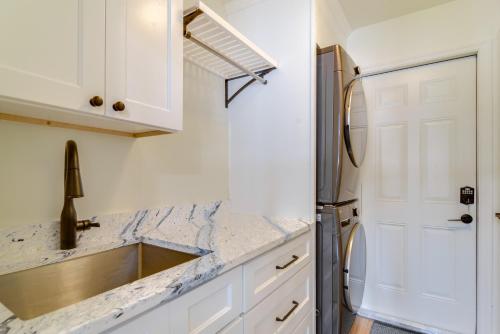a kitchen with white cabinets and a stainless steel refrigerator at Riverfront Ruskin Home with Boat Dock, 1 Mi to Beach in Ruskin