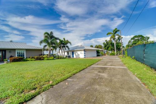 a driveway in front of a house with palm trees at Riverfront Ruskin Home with Boat Dock, 1 Mi to Beach in Ruskin