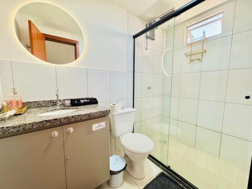 a bathroom with a toilet and a glass shower at Apê confortável com garagem e espaço de trabalho in Cuiabá
