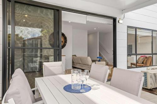 a dining room with a white table and chairs at Townhouse in Marks Point in Marks Point