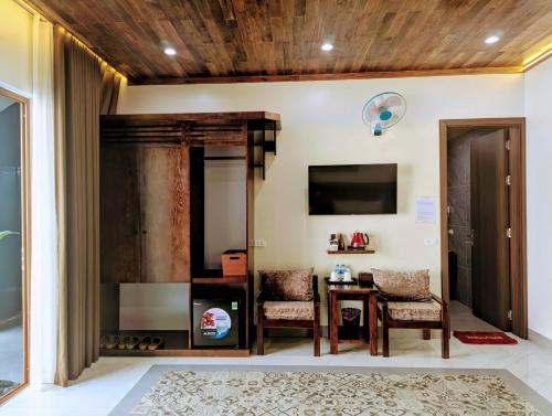 a living room with a table and chairs and a tv at Daisy's Villa TamCoc in Vũ Lâm