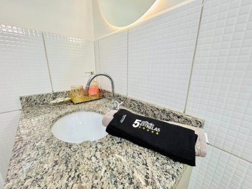 un lavandino del bagno con una camicia nera su un bancone di Apê ideal para Você, com Academia e Piscina a Cuiabá