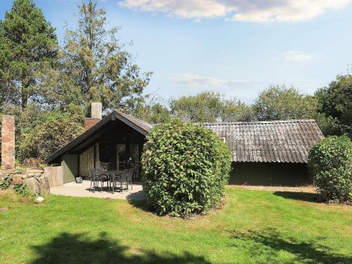 a building with a table and chairs in front of it at 5 person holiday home in Rødby-By Traum in Rødby