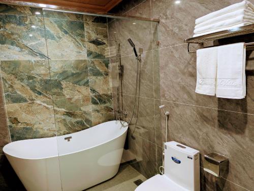 a bathroom with a toilet and a glass shower at Daisy's Villa TamCoc in Vũ Lâm