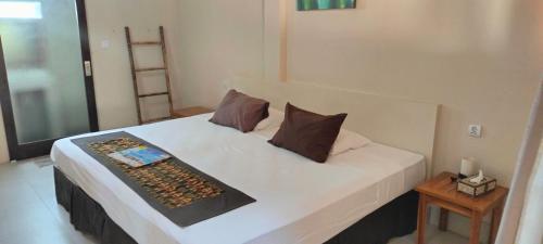 ein Schlafzimmer mit einem weißen Bett und zwei Kissen in der Unterkunft Trawangan Oasis in Gili Trawangan