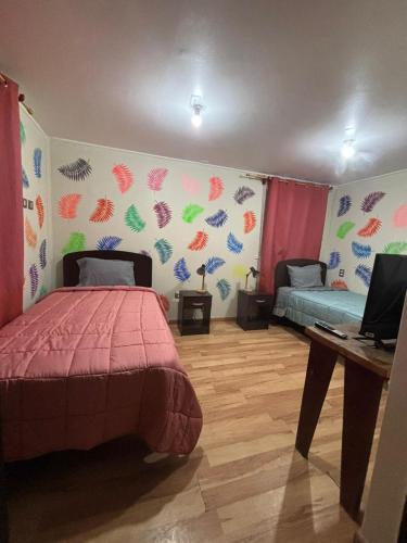 a bedroom with a bed and a desk in it at Hotel Minga in Copiapó