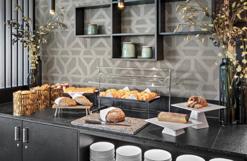 a bakery with bread and pastries on a counter at Leonardo Hotel Vienna City West in Vienna