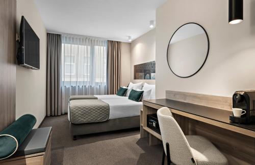 a hotel room with a bed and a mirror at Leonardo Hotel Vienna City West in Vienna