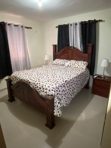 a bedroom with a wooden bed in a room with curtains at Residencial Garden City in Colorado
