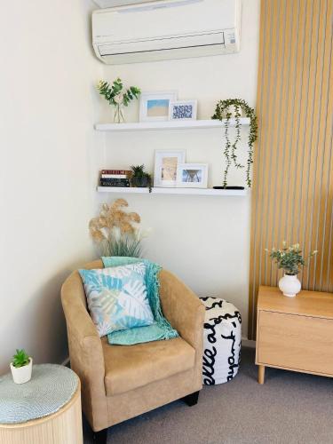 a living room with a chair and a table at GREENVIEW, BFast,WiFi,Fetch, Walk2Pizza,Liquor in Bell Post Hill