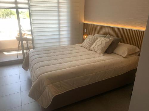 a large bed in a bedroom with a window at Apartamento Playa y piscina, Santa Marta in Santa Marta