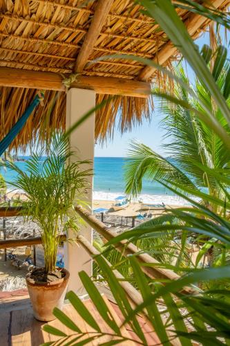 a view of the beach from a resort with palm trees at Casa Estrella Fugaz Rinconcito Mazunte in Santa María Tonameca