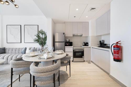 a kitchen and living room with a table and chairs at DVH Luxe Retreats 1BR Yas Island by Ferrari World and Yas Mall in Yas Island