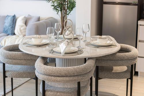 a dining room table with chairs and wine glasses at DVH Luxe Retreats 1BR Yas Island by Ferrari World and Yas Mall in Yas Island
