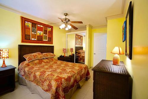 a bedroom with a bed and a ceiling fan at Garden condos, unit#8 in Sosúa
