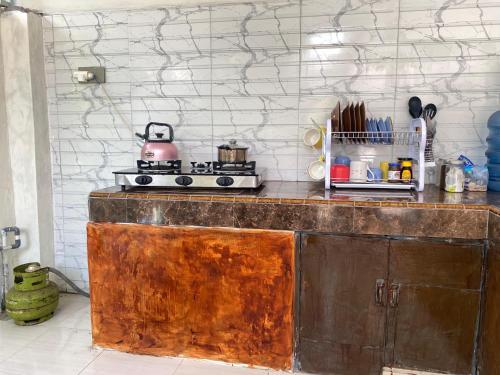 a kitchen with a stove and a counter top at Neo Robiu & Ijen Tour in Banyuwangi