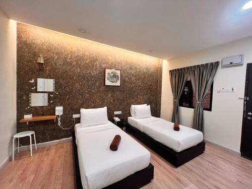 a hotel room with two beds in a room at Sim Vintage Villa Langkawi in Kuah