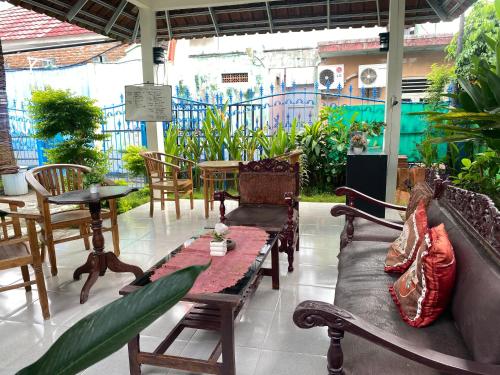 a patio with chairs and a couch and a table at Neo Robiu & Ijen Tour in Banyuwangi